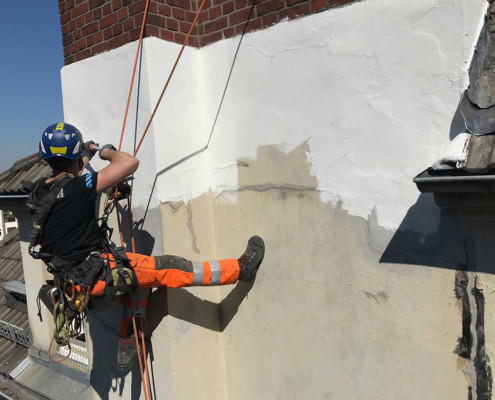 Außenanstrich einer Fassade mithilfe von Seilzugangstechnik