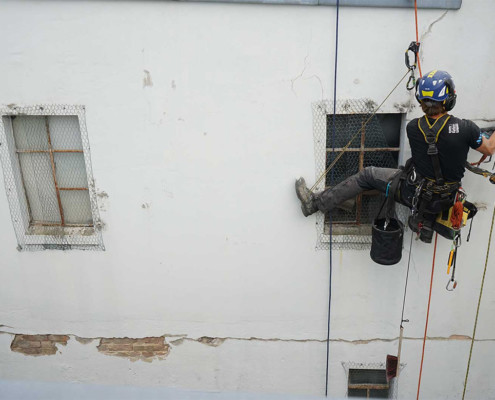 Kletterer repariert Risse an der Fassade