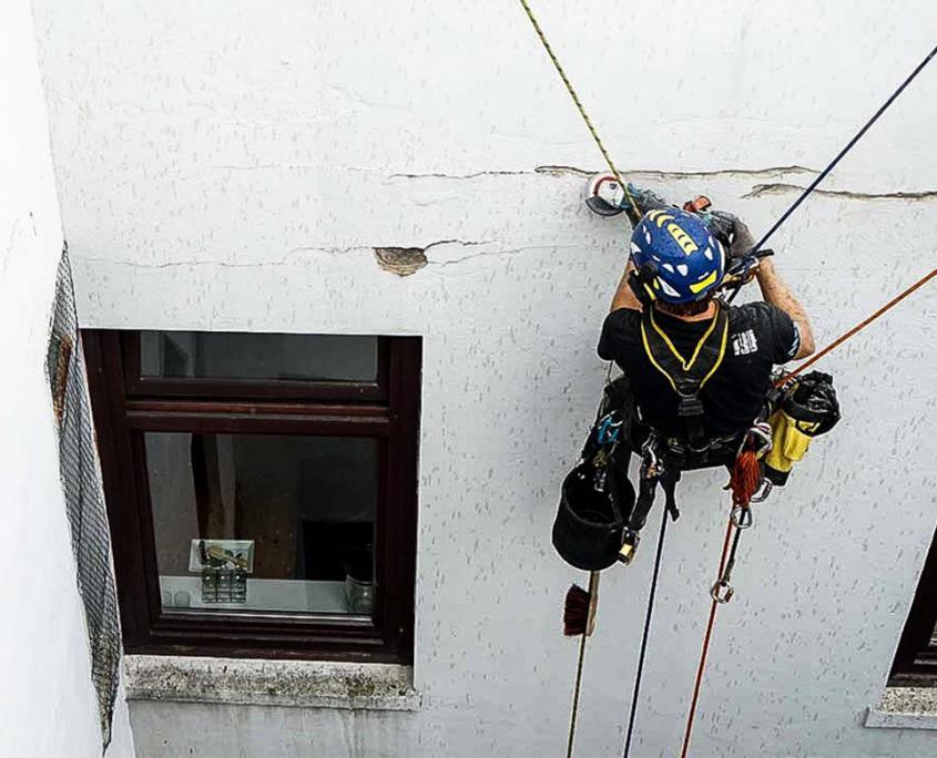 Reparatur einer Fassade mithilfe von Seilzugangstechnik